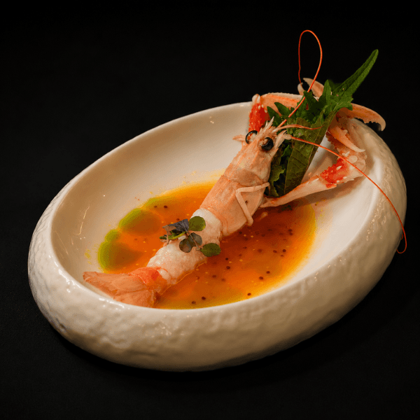 Prawn in ponzu sauce with herbs in a white bowl